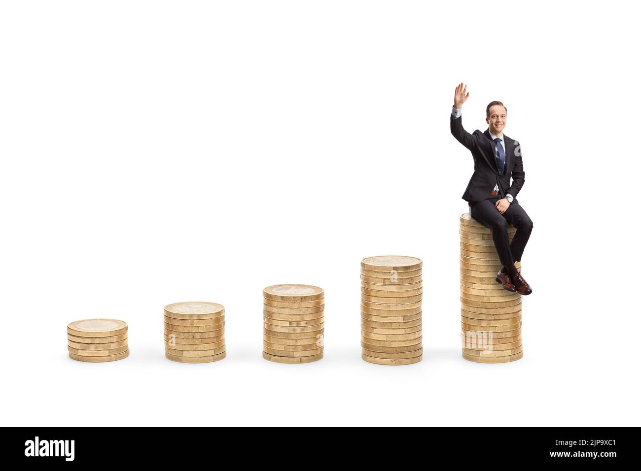 Businessman sitting on a pile of coins and waving at camera isolated on white background Stock Photo
