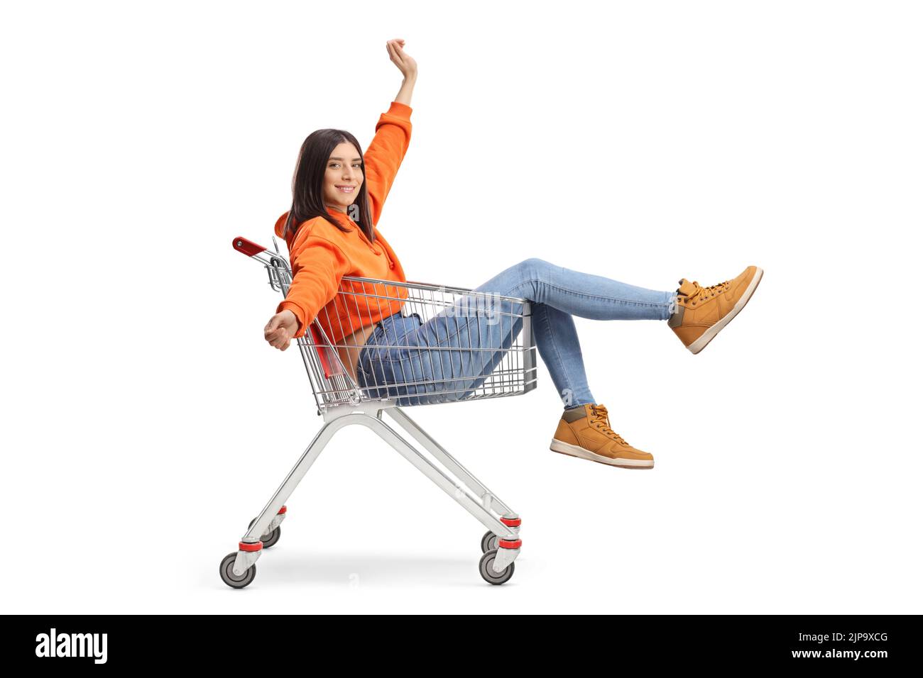 Young happy female sitting inside a shopping cart isolated on white background Stock Photo