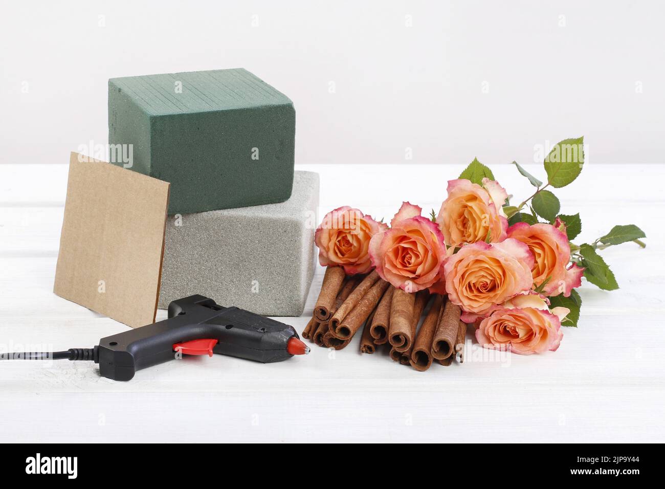Florist at work How to make floral arrangement with roses and cinnamon