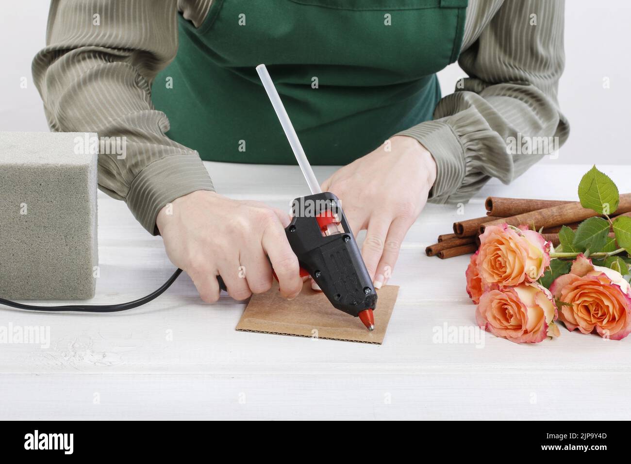 Florist at work How to make floral arrangement with roses and cinnamon