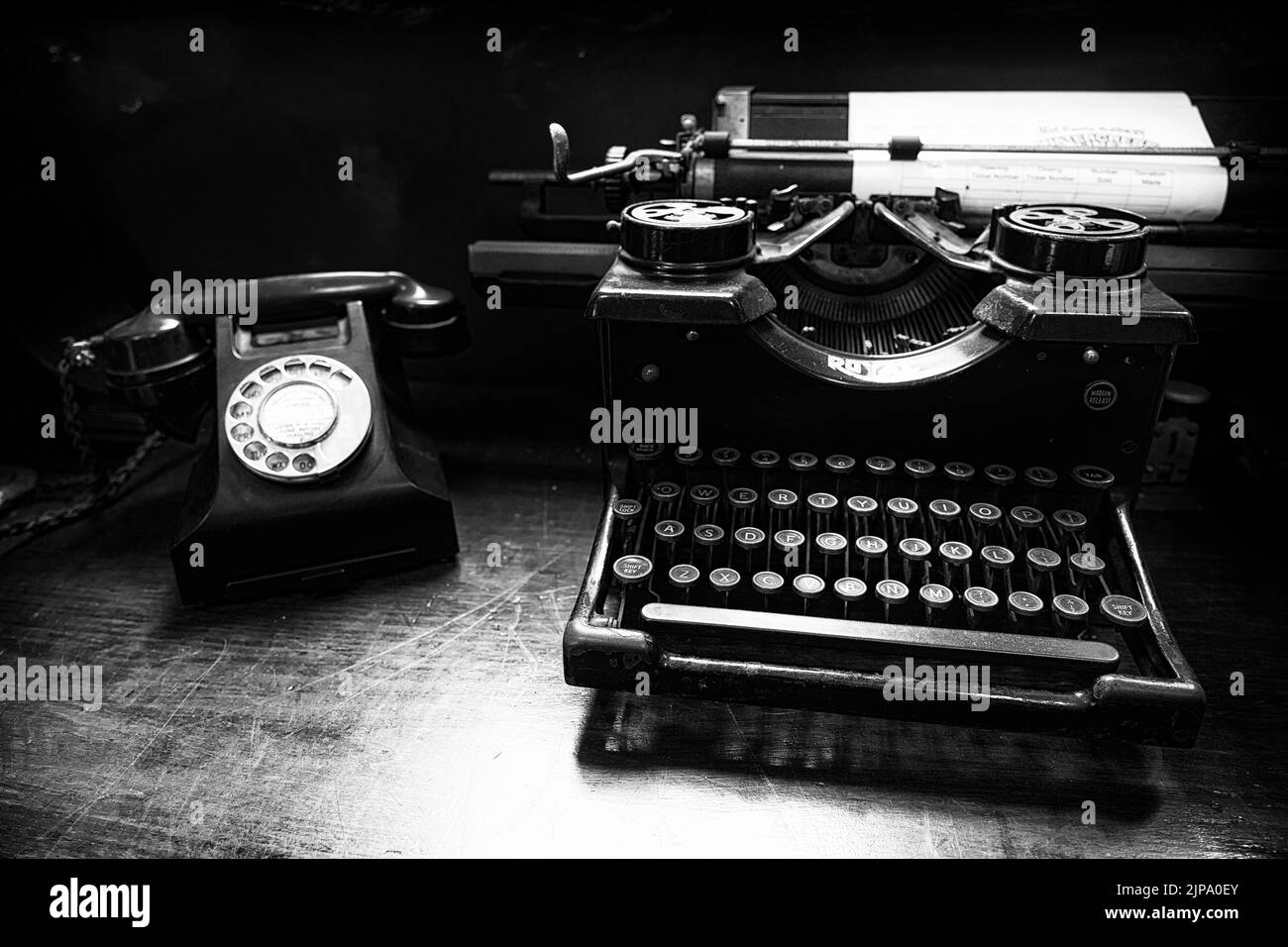 An old retro phone near retro typewriter in black and white Stock Photo