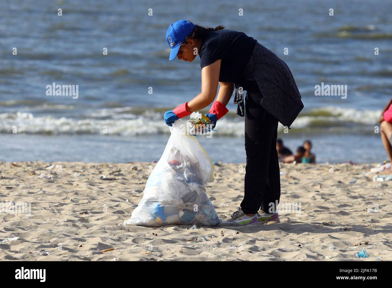 (220816) -- ALEXANDRIA, Aug. 16, 2022 (Xinhua) -- A woman collects waste from the beach in Alexandria, Egypt, Aug. 13, 2022. On the beaches in the Egyptian city of Alexandria, a group of Egyptian young people are usually seen holding green and white plastic bags to collect the scattering waste. They are participants in a cleanup campaign organized by Banlastic Egypt, an environmental project launched by a group of youth in the Mediterranean city. The project seeks to raise the public's awareness of plastic pollution and how single-use plastic waste harms marine life if it eventually end Stock Photo