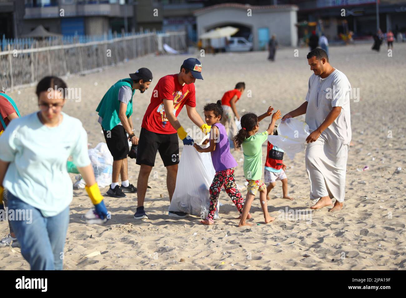 (220816) -- ALEXANDRIA, Aug. 16, 2022 (Xinhua) -- People collect waste from the beach in Alexandria, Egypt, Aug. 13, 2022. On the beaches in the Egyptian city of Alexandria, a group of Egyptian young people are usually seen holding green and white plastic bags to collect the scattering waste. They are participants in a cleanup campaign organized by Banlastic Egypt, an environmental project launched by a group of youth in the Mediterranean city. The project seeks to raise the public's awareness of plastic pollution and how single-use plastic waste harms marine life if it eventually ends up Stock Photo