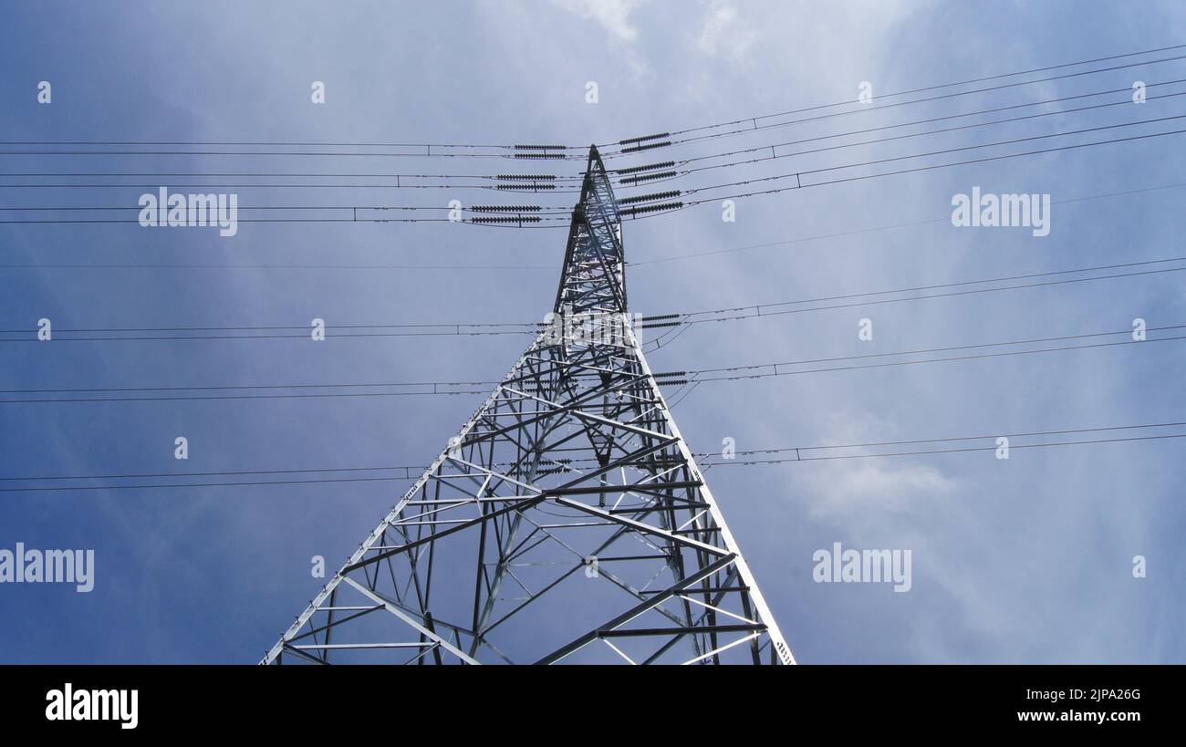 High voltage power lines in front of a blue sky Stock Photo - Alamy