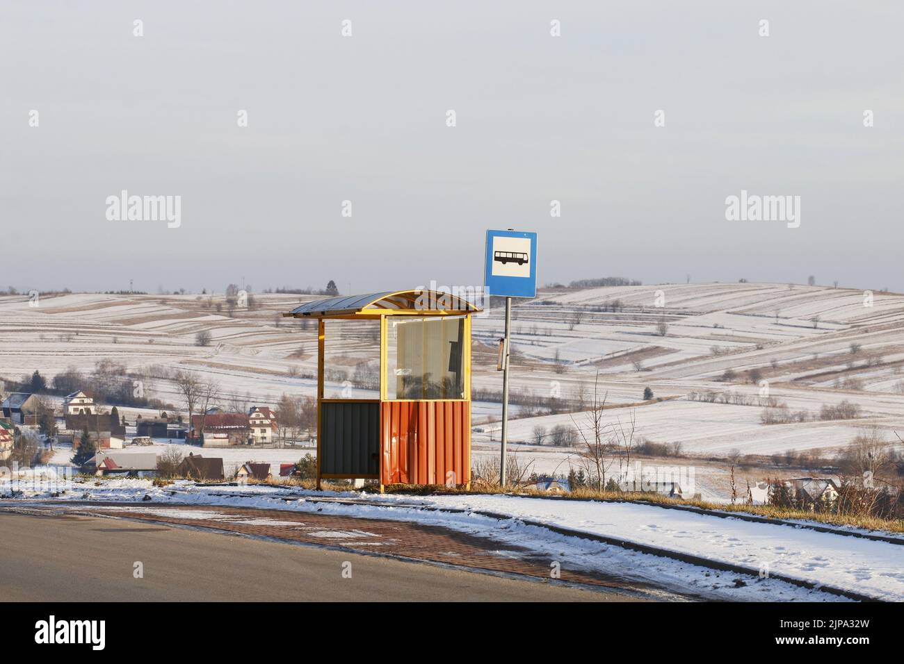 Vintage bus stop on a country road among fields, away from the village