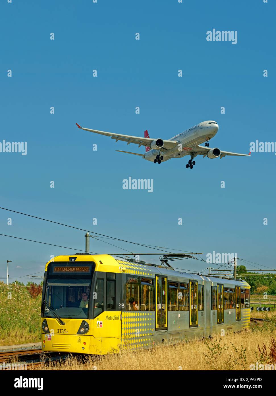 Manchester Metrolink tram and Turkish Airlines aircraft approaching the
