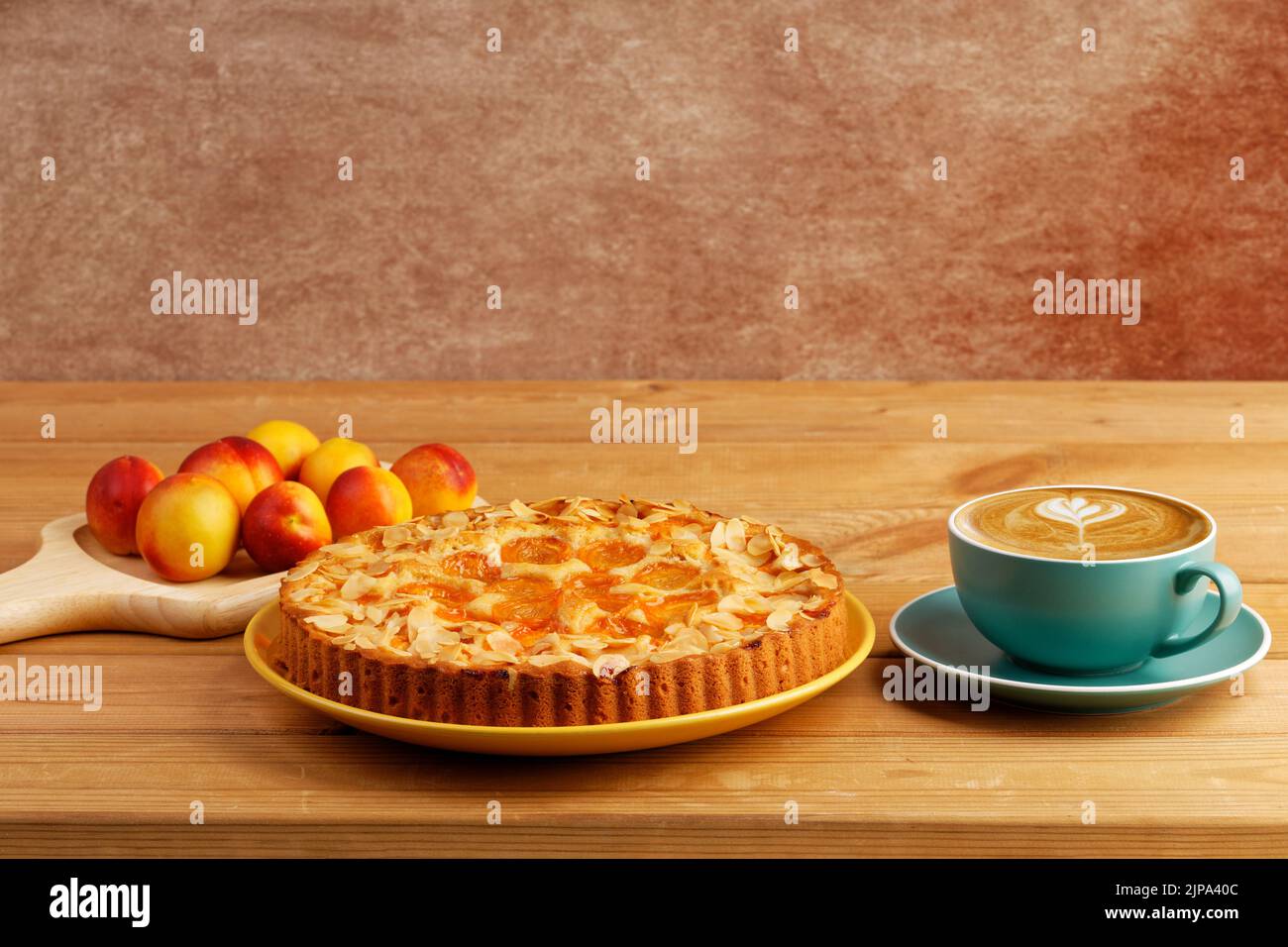 Homemade pie with apricots and cup of coffee cappuccino on wooden table. Copyspace. Stock Photo