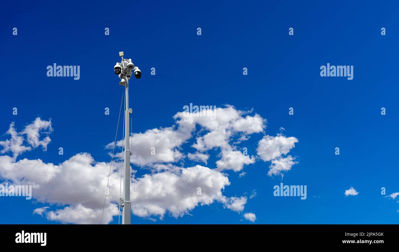 Low angle view of a CCTV mobile camera with clouds and blue sky Stock Photo