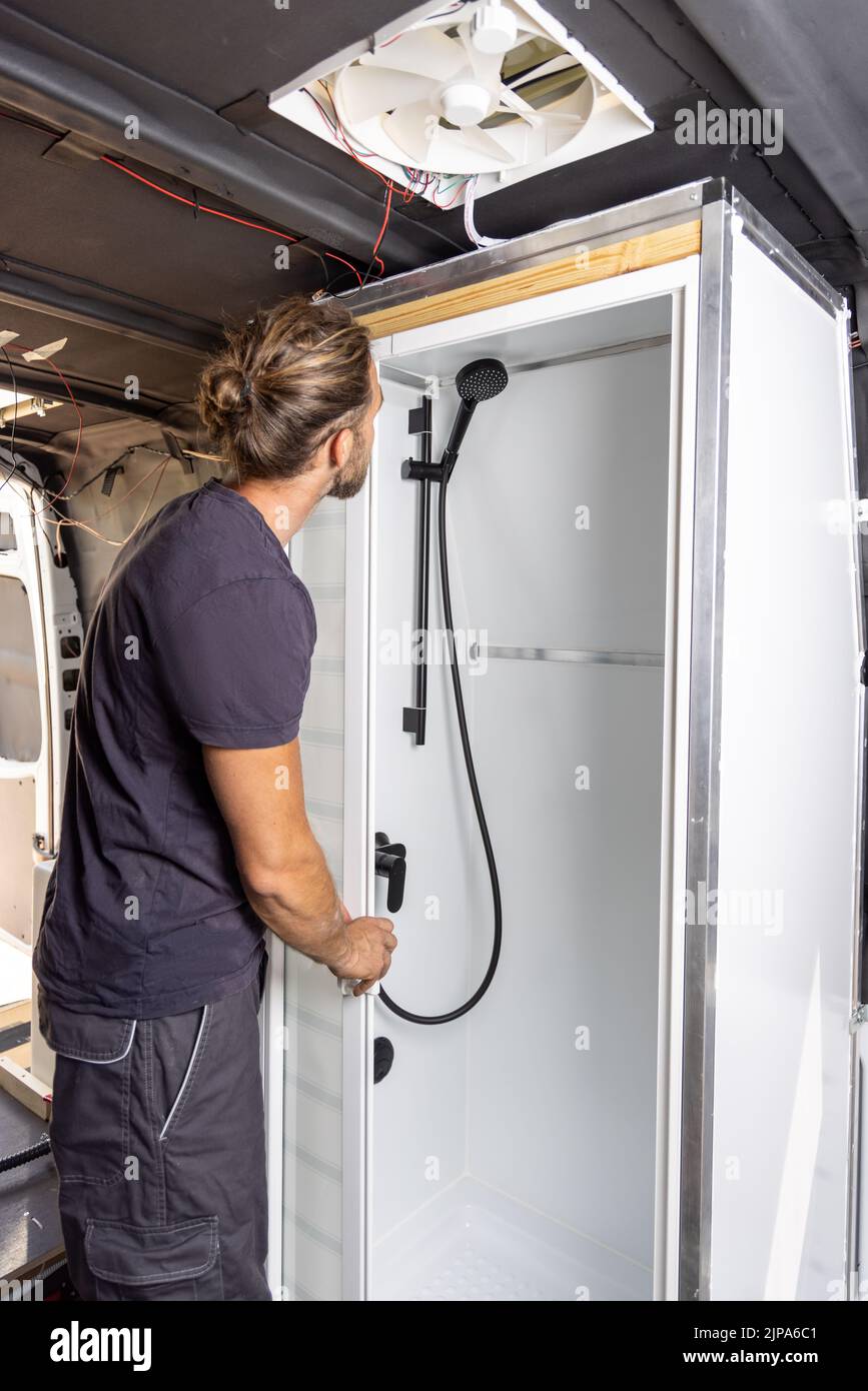 Man building a shower room inside a camper van Stock Photo Alamy