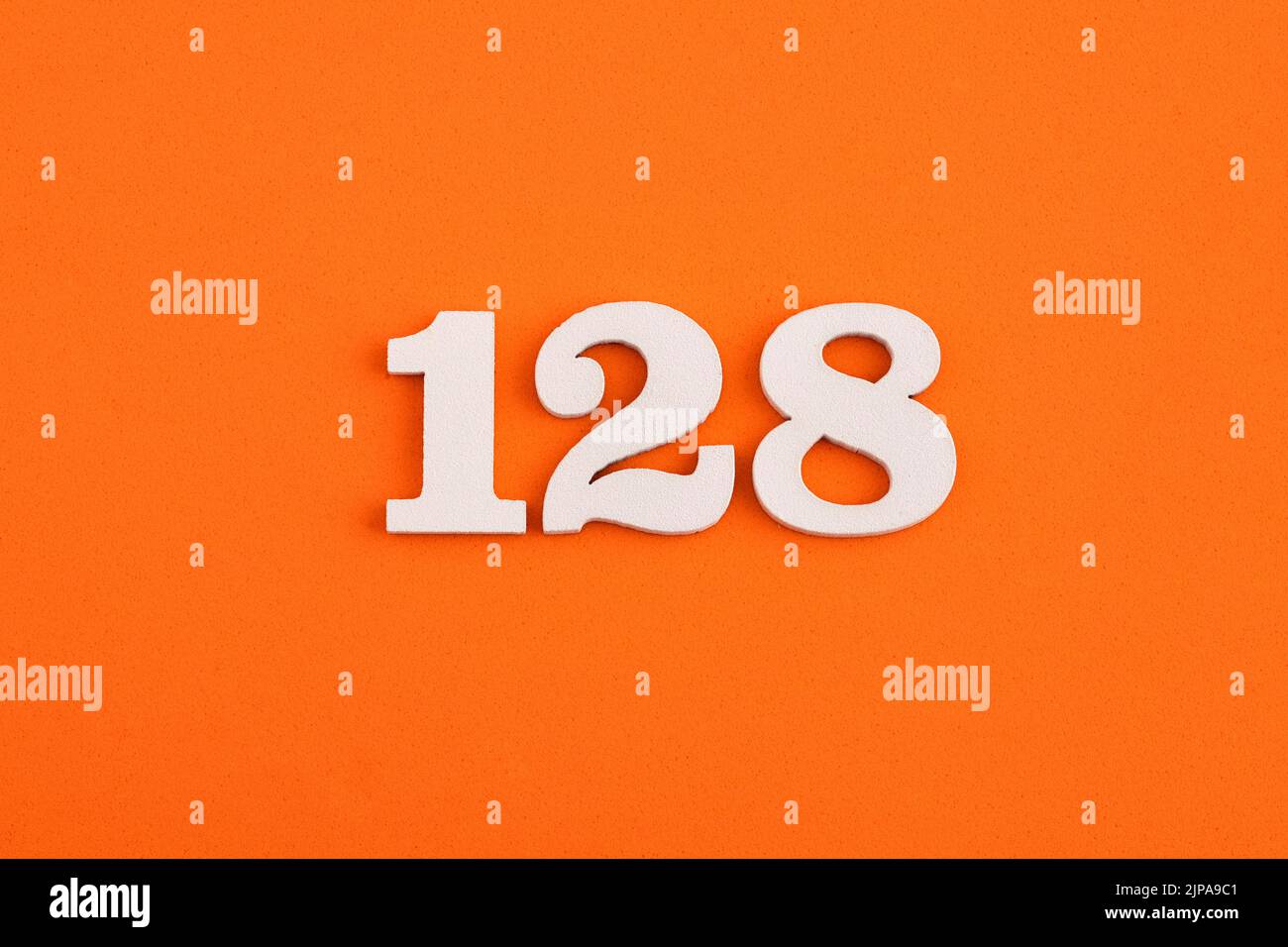 White wooden number 128 on eva rubber orange background Stock Photo Alamy