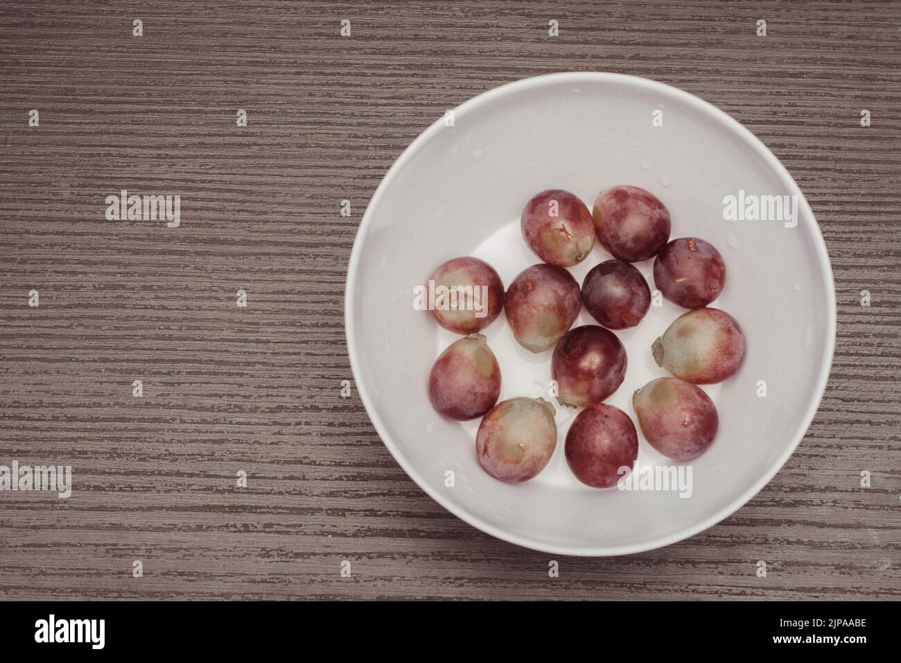 plate with a serving of fresh red globe grapes, a healthy snack for pre