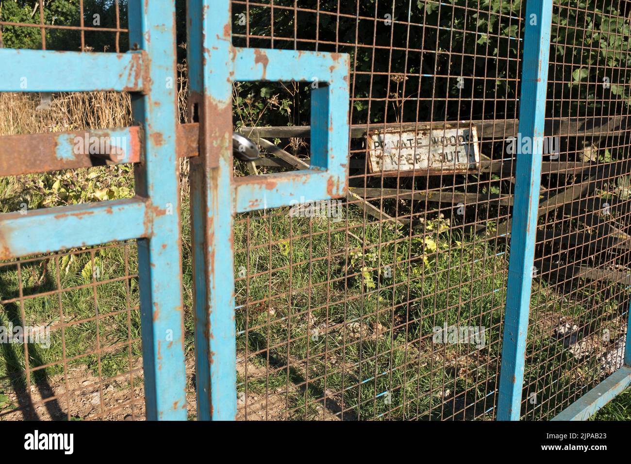 dh Fence gates WOODS YORKSHIRE Private wood keep out sign security steel metal mesh gate preventing access wire property written forest Stock Photo