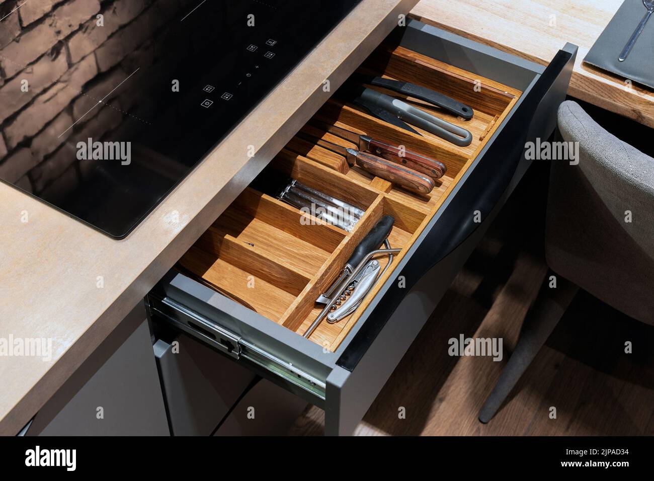 Modern kitchen. Set of cutlery trays in kitchen drawer. Solid oak wood cutlery drawer inserts. Stock Photo