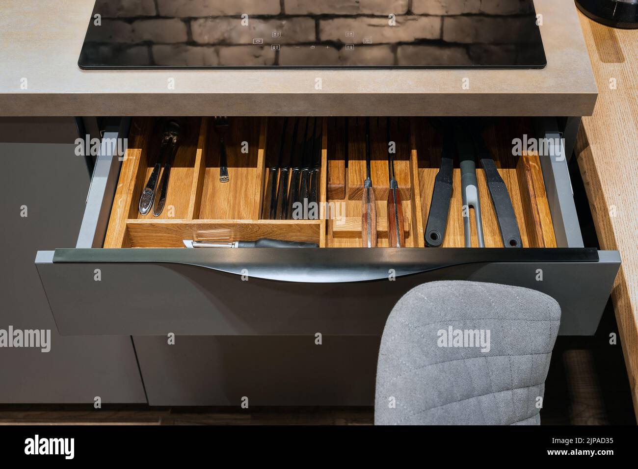 Modern kitchen. Set of cutlery trays in kitchen drawer. Solid oak wood