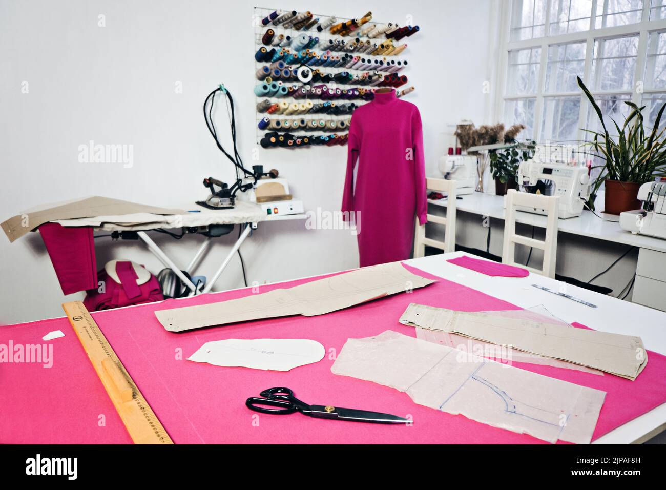 Fashion designer working studio interior with workplace table, fabric  materials and sewing patterns for clothes designing, tailoring. Atelier  workshop space. Small business and self employment concept Stock Photo