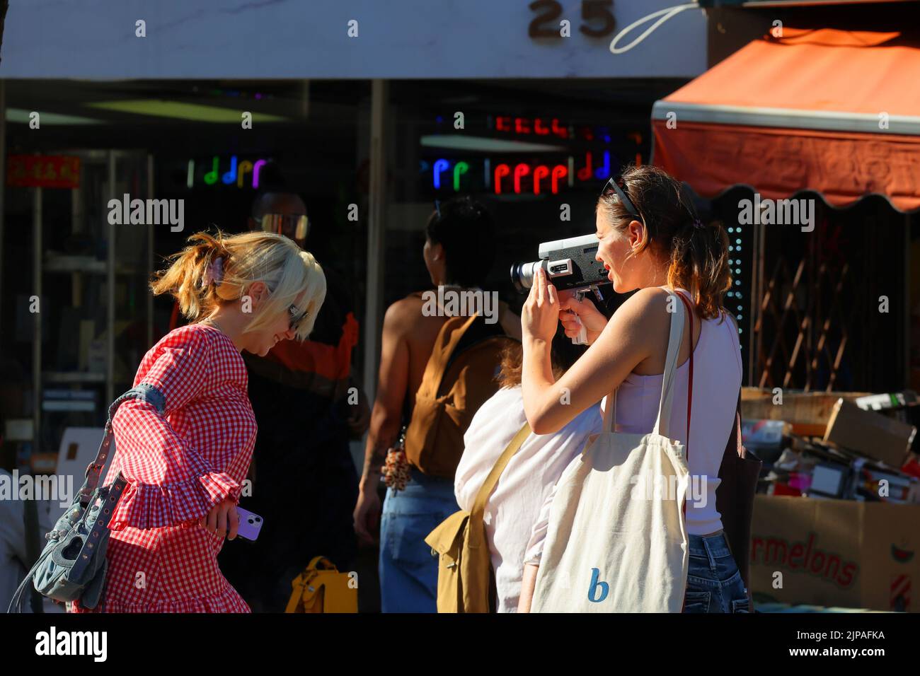 Woman indie filmmakers with a Canon Zoom 318 Super 8 film camera in Manhattan's 'Dimes Square' Chinatown/Lower East Side Stock Photo