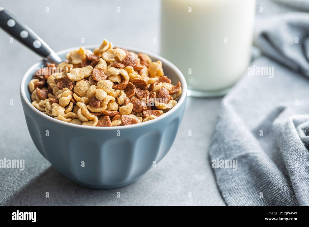 Breakfast cereal flakes in a bowl on kitchen table. Stock Photo