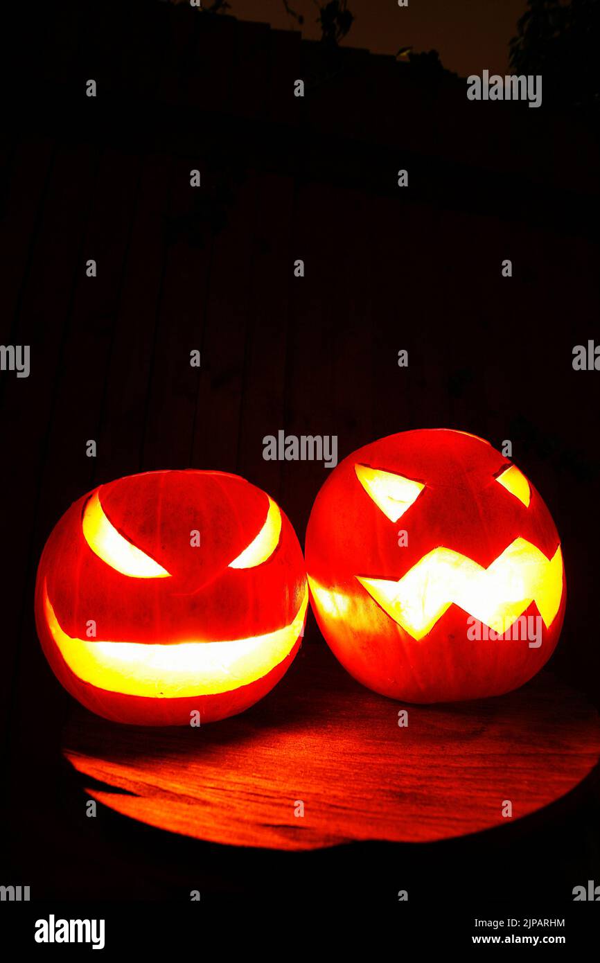 closeup of scary halloween pumpkins on black dark background Stock Photo