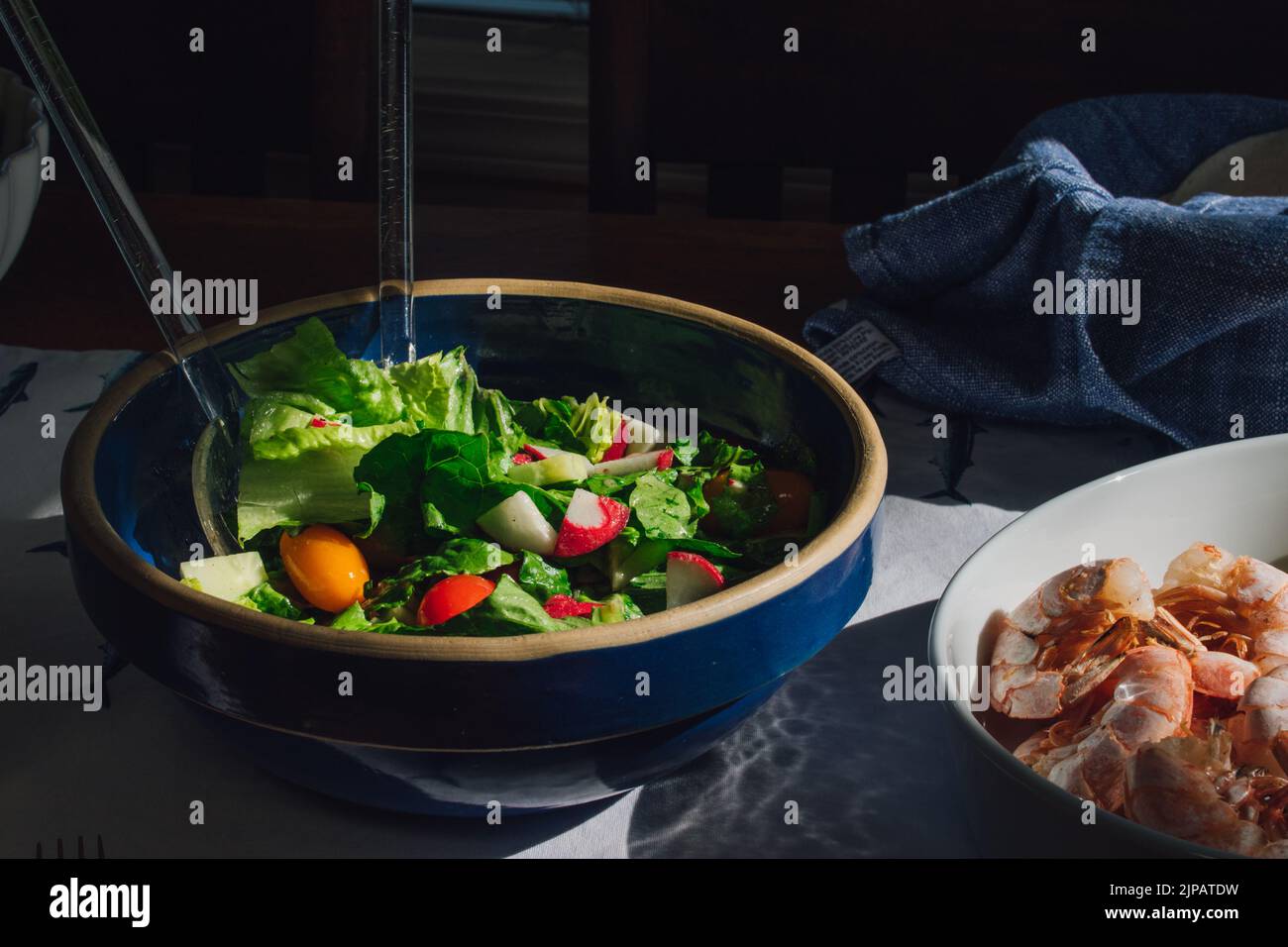 lettuce salad with tomato, radish in blue bowl Stock Photo