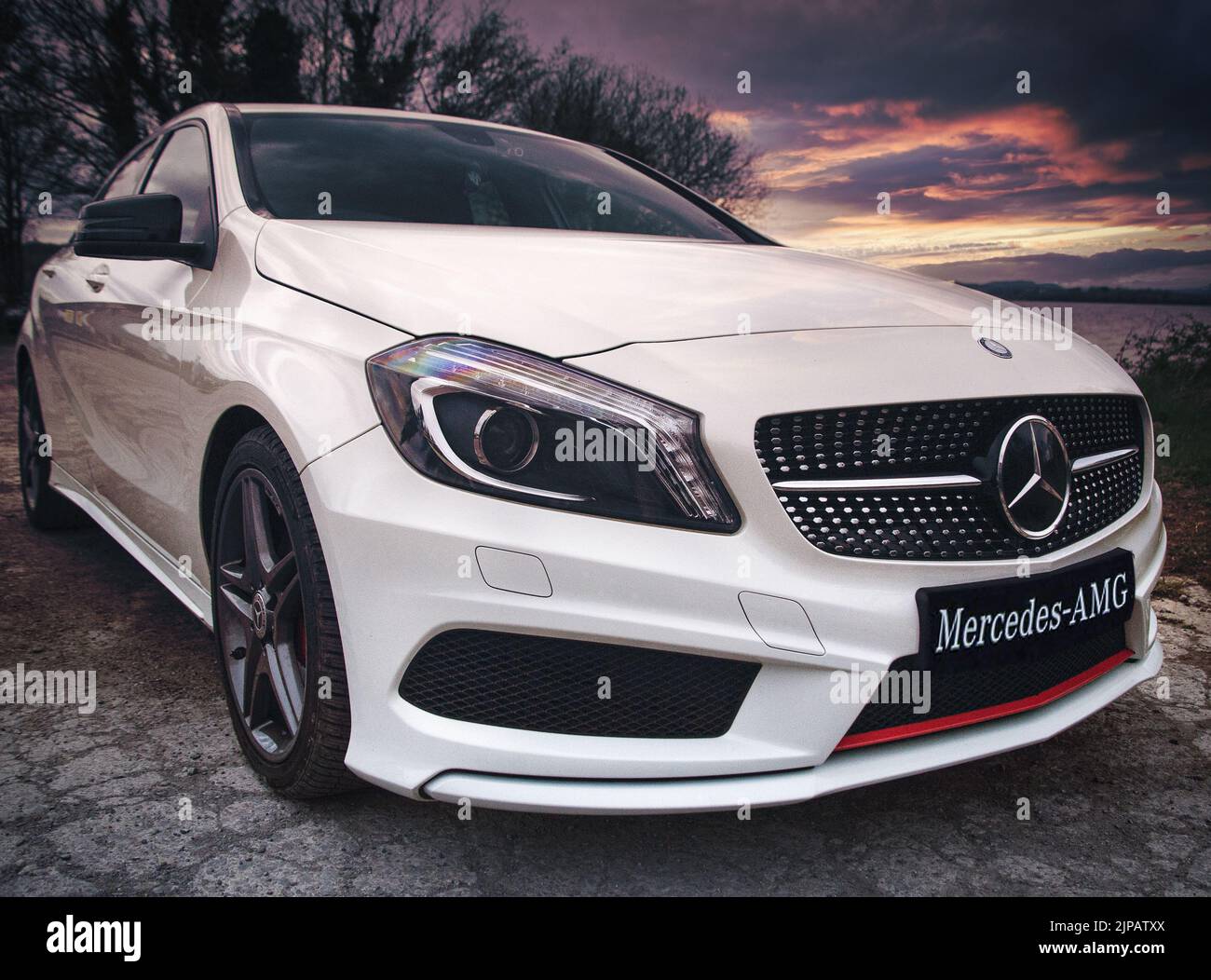 A luxury Mercedes Benz A class car parked in a park during sunset Stock Photo