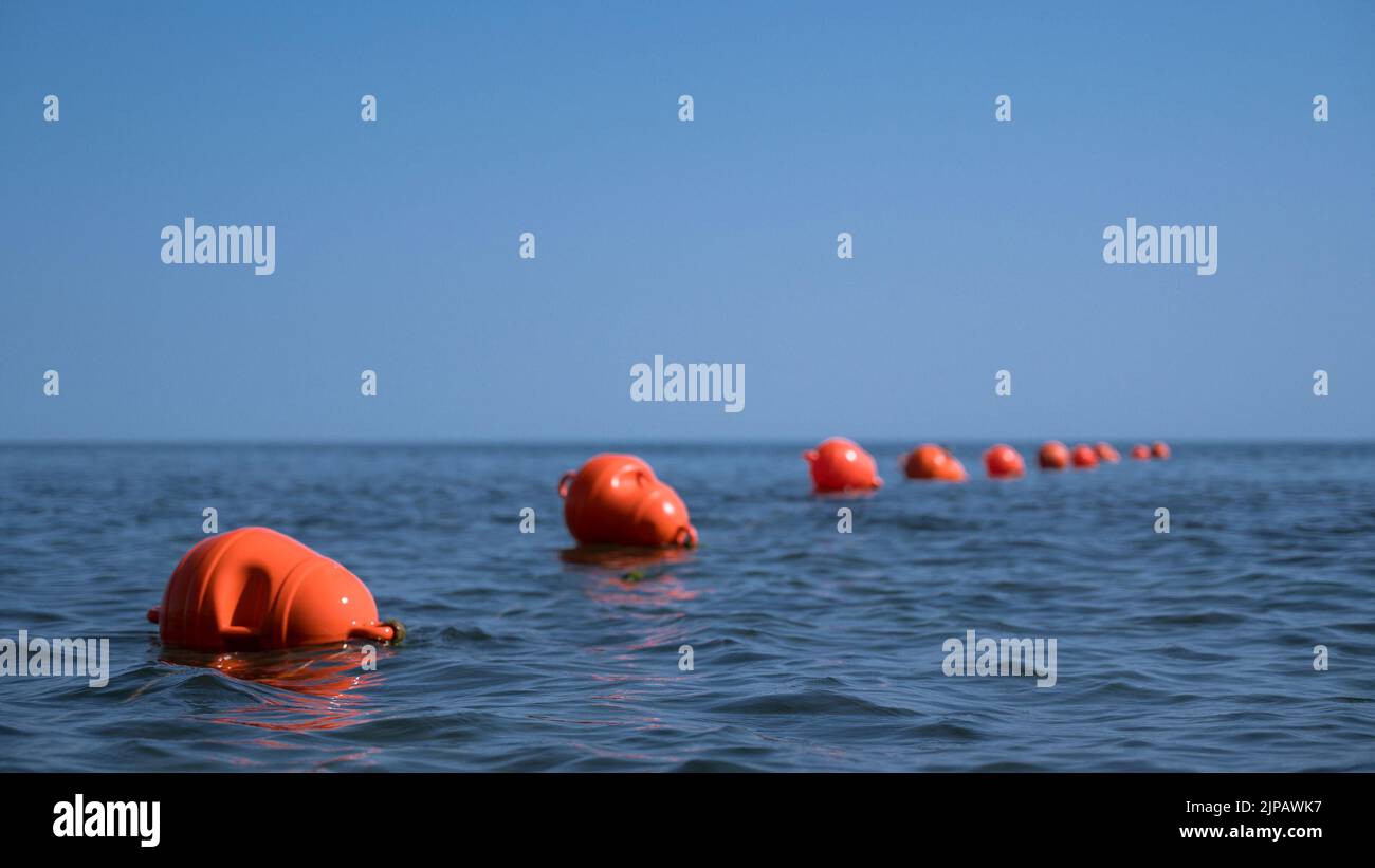 Orange floating buoys in the sea. Human life saving concept. Blue sky. Stock Photo
