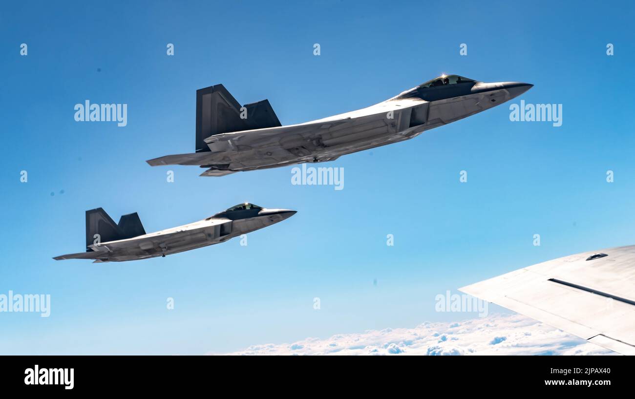 Lask, Poland. 10 August, 2022. U.S. Air Force F-22 Raptor fighter jets, assigned to the 90th Fighter Squadron, fly in formation alongside a KC-135 Stratotanker refueling aircraft during a NATO Air Shielding mission, August 10, 2022 over Lask, Poland.   Credit: SSgt. Kevin Long/U.S. Air Force/Alamy Live News Stock Photo