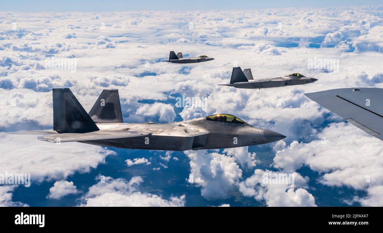 Lask, Poland. 10 August, 2022. U.S. Air Force F-22 Raptor fighter jets, assigned to the 90th Fighter Squadron, fly in formation alongside a KC-135 Stratotanker refueling aircraft during a NATO Air Shielding mission, August 10, 2022 over Lask, Poland.   Credit: SSgt. Kevin Long/U.S. Air Force/Alamy Live News Stock Photo
