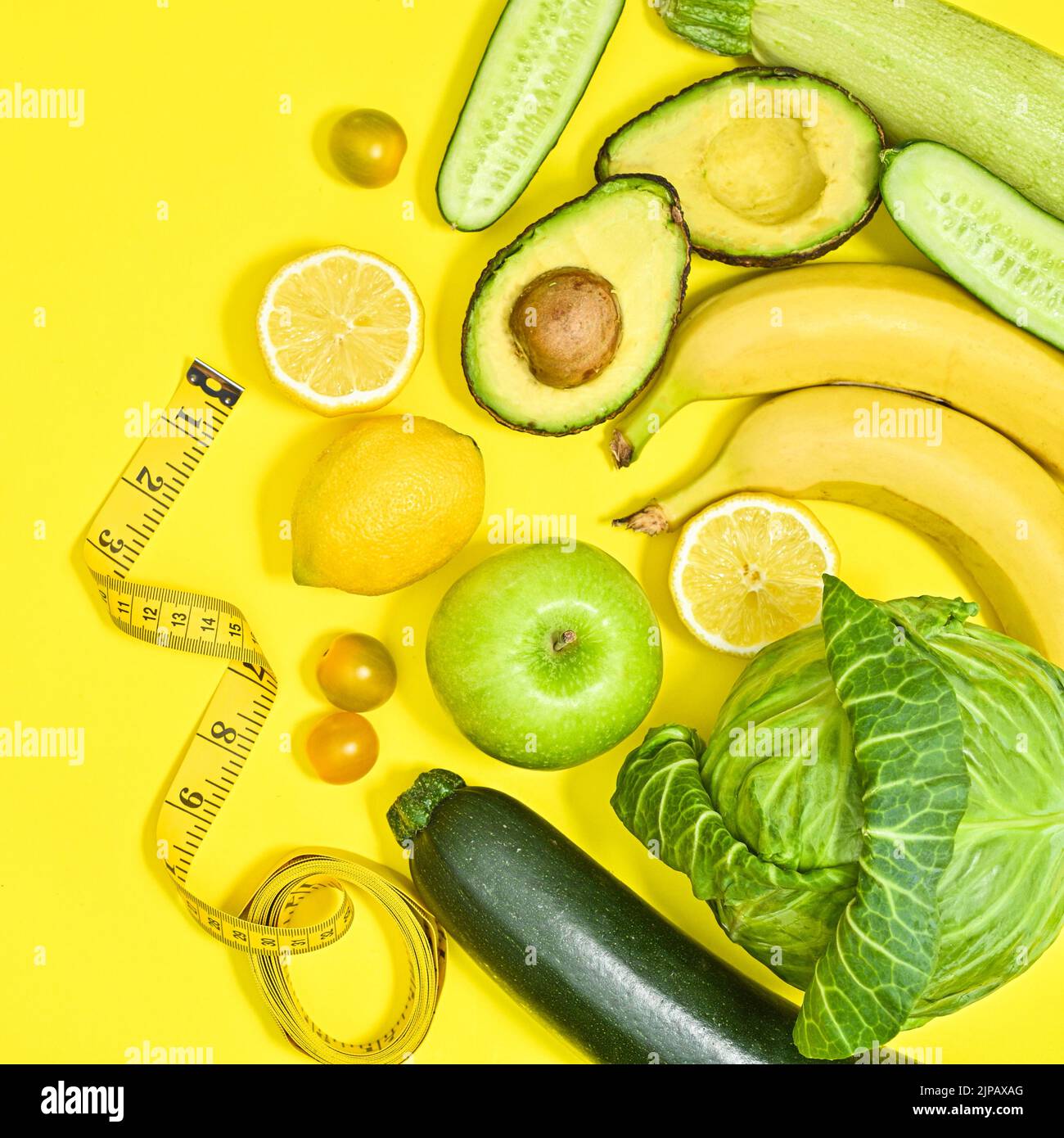 Creative yellow background with green and antioxidant fruits and ...