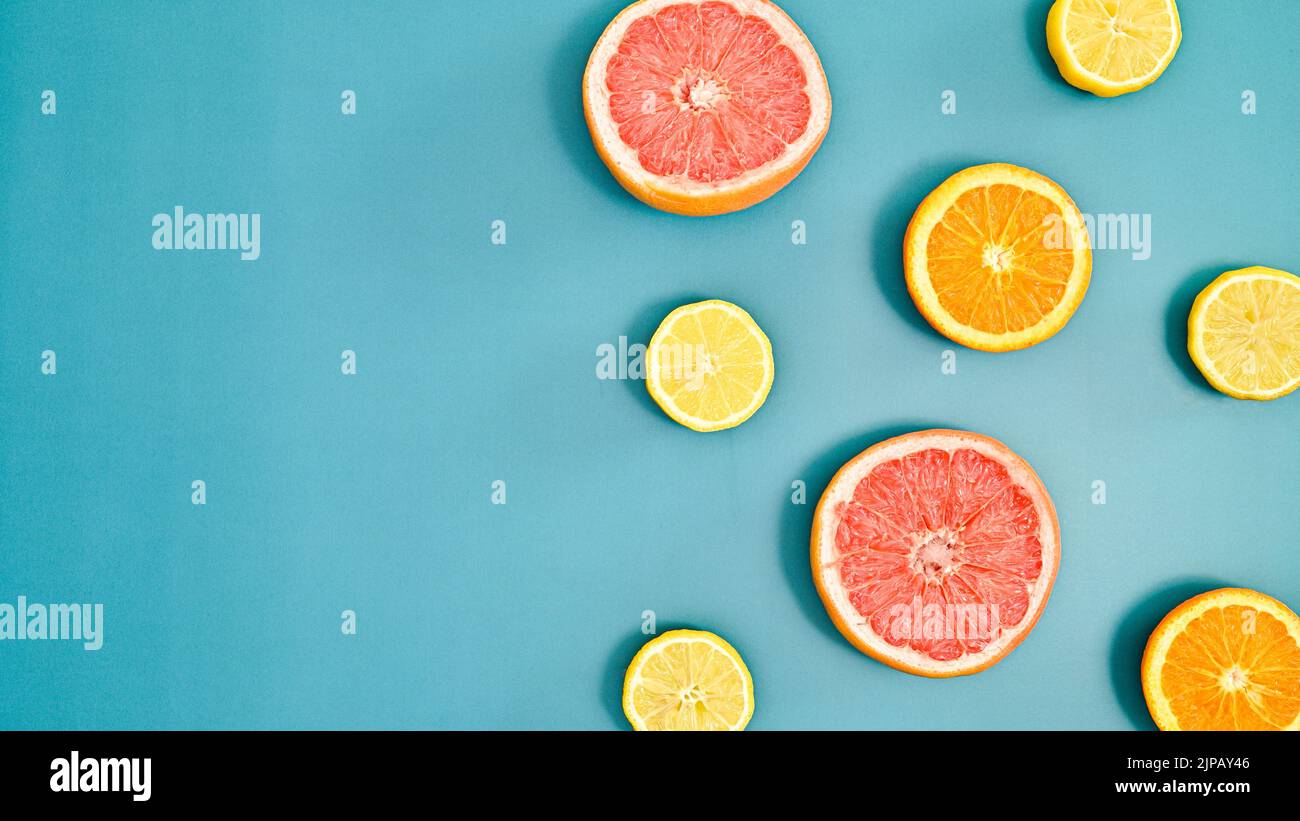 Summer creative oranges, lemons and grapefruits pattern with copy space on bluebackground. Tropic citrus fruits concept. Flat lay Stock Photo