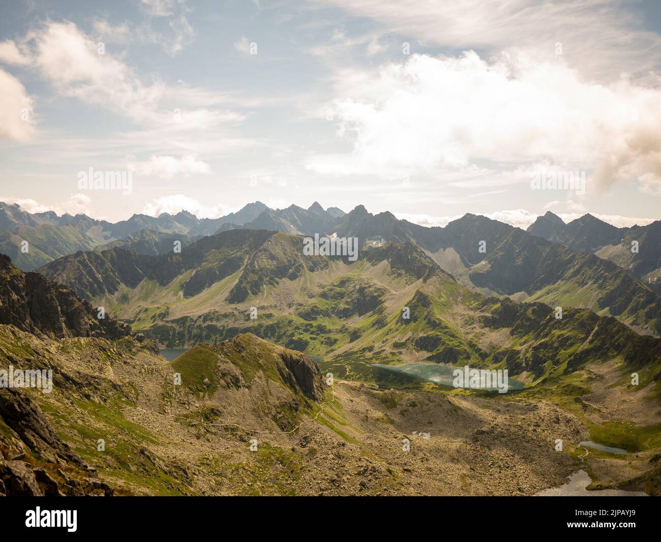 An aerial landscape view of green mountains with huge white clouds in ...