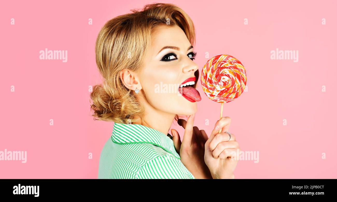 Girl licking lollipop. Beautiful woman with red lips eat sweats lolly pop. Sexy model sucking candy. Stock Photo