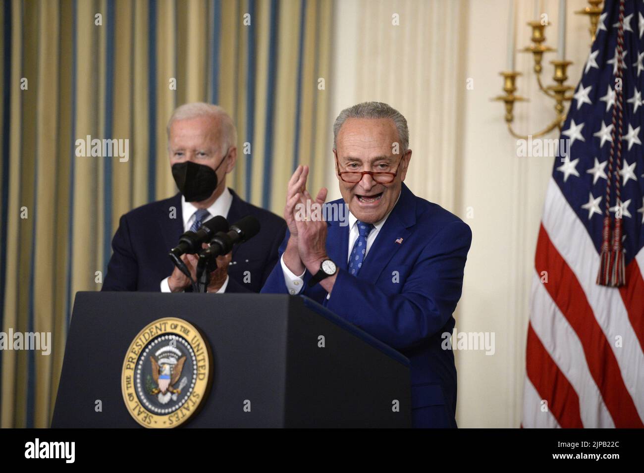 Washington, United States. 16th Aug, 2022. Senate Majority Leader Chuck Schumer, D-NY, speaks as President Joe Biden looks on during a bill signing ceremony for the Inflation Reduction Act of 2022, a $737 billion act focused on slowing climate change, lowering health care costs and creating more clean energy jobs, in the State Dining Room at the White House in Washington, DC on Tuesday, August 16, 2022. Photo by Bonnie Cash/UPI Credit: UPI/Alamy Live News Stock Photo