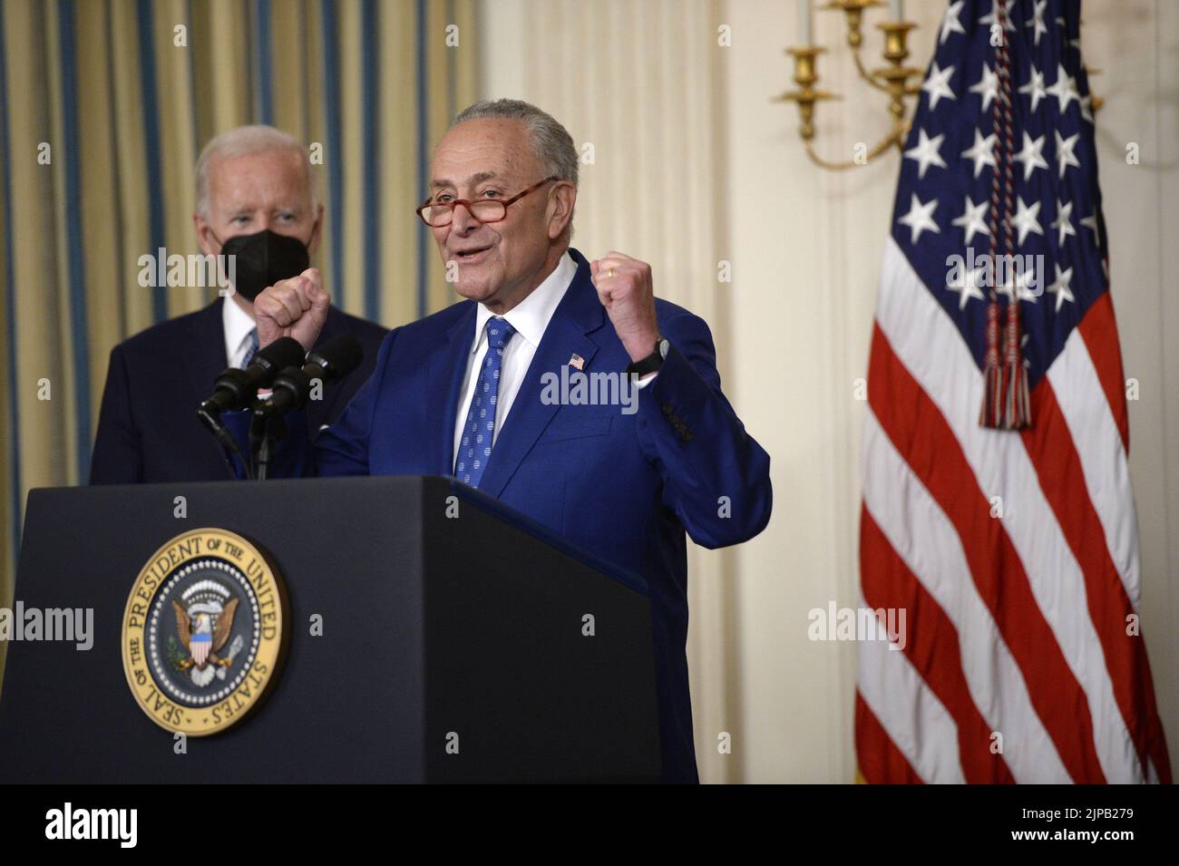 Washington, United States. 16th Aug, 2022. Senate Majority Leader Chuck Schumer, D-NY, speaks as President Joe Biden looks on during a bill signing ceremony for the Inflation Reduction Act of 2022, a $737 billion act focused on slowing climate change, lowering health care costs and creating more clean energy jobs, in the State Dining Room at the White House in Washington, DC on Tuesday, August 16, 2022. Photo by Bonnie Cash/UPI Credit: UPI/Alamy Live News Stock Photo