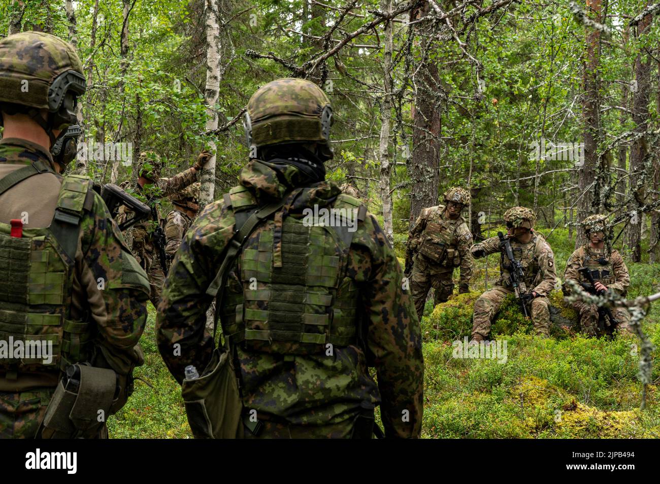 U.S. Soldiers with 1st Battalion, 26th Infantry Regiment, 2nd Brigade Combat Team, 101st Airborne Division (Air Assault) and Finnish army soldiers with the Jeager Brigade perform an after action review following a company situational training exercise part of joint training between the U.S. Army and Finnish army at Rovaniemi, Finland, Aug. 10, 2022. (U.S. Army photo by Capt. Tobias Cukale) Stock Photo