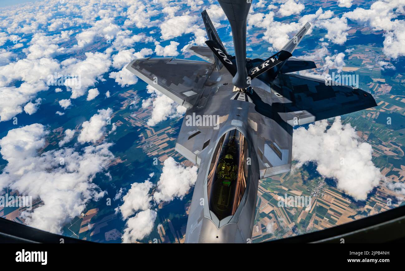 A U.S. Air Force KC-135 Stratotanker aircraft assigned to the 100th Air Refueling Wing, Royal Air Force Mildenhall, England refuels a U.S. Air Force F-22 Raptor aircraft assigned to the 90th Fighter Squadron, Joint Base Elmendorf-Richardson, Alaska, over Poland, Aug. 10, 2022.  The 100th ARW provides the critical air refueling bridge that enables strategic assets to operate in forward locations, and postures NATO forces to extend global reach and amplify operational capability throughout Europe. (U.S. Air Force photo by Staff Sgt. Kevin Long) Stock Photo