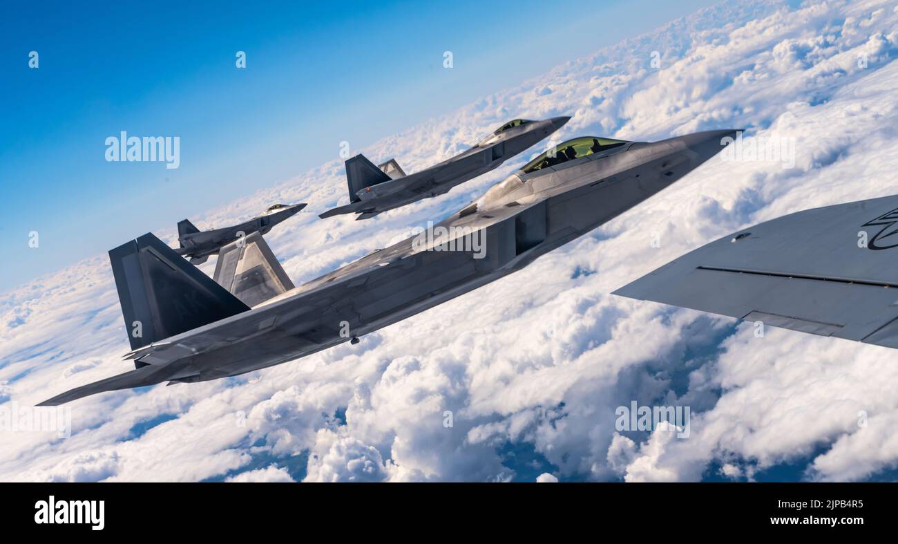 Three U.S. Air Force F-22 Raptor aircraft assigned to the 90th Fighter Squadron, Joint Base Elmendorf-Richardson, Alaska, fly alongside a U.S. Air Force KC-135 Stratotanker aircraft assigned to the 100th Air Refueling Wing at Royal Air Force Mildenhall, England, over Poland, Aug. 10, 2022. The NATO Air Shielding mission provides a near seamless shield from the Baltic to Black Seas, ensuring NATO Allies are better able to safeguard and protect Alliance territory, populations and forces from air and missile threat. (U.S. Air Force photo by Staff Sgt. Kevin Long) Stock Photo