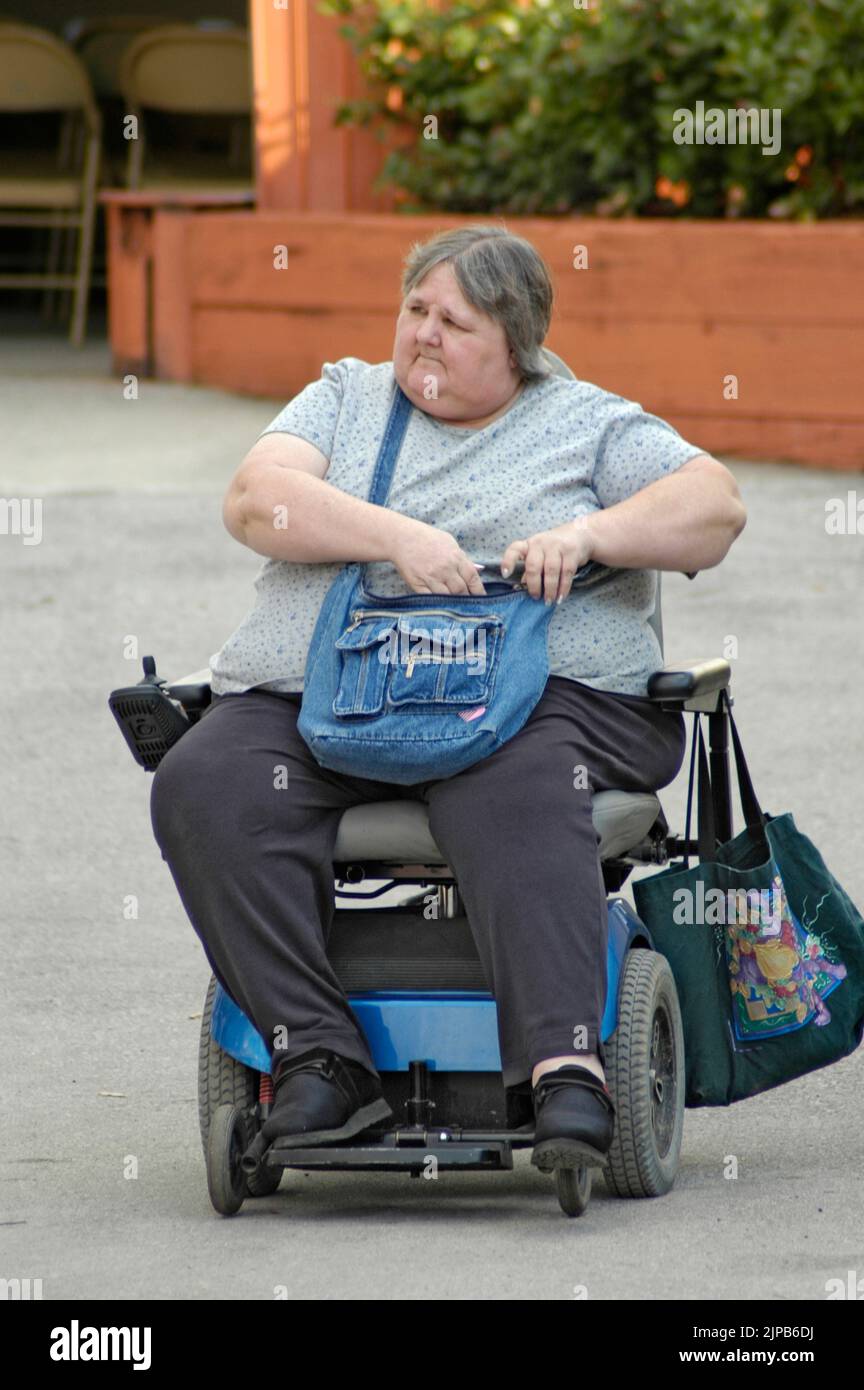People confined to wheelchairs and walkers at the Florida State Fair grounds Seniors Obese Stock