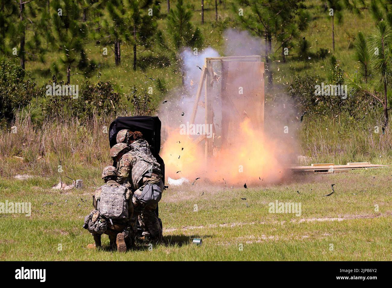 July 27, 2022 - Camp Shelby, Mississippi, USA - U.S. Army Reserve Soldiers, assigned to the 344th Engineer Company based in Tallahassee, Florida, take cover behind a blast blanket while detonating a linear det charge placed on a door hinge to create an entry point during the Pershing Strike mobilization exercise. The training prepared Soldiers in breaching obstacles when deployed and attached to a cavalry, scout or infantry platoons. Pershing Strike was the most sizable, large scale mobilization exercise to date at the historic Camp Shelby in Mississippi that tested stressors at a Mobilization Stock Photo