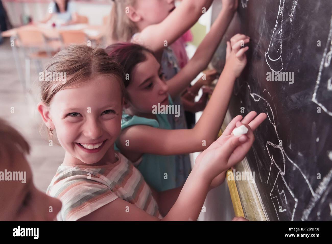 Children write and draw on the blackboard in elementary school while learning the basics of education Stock Photo