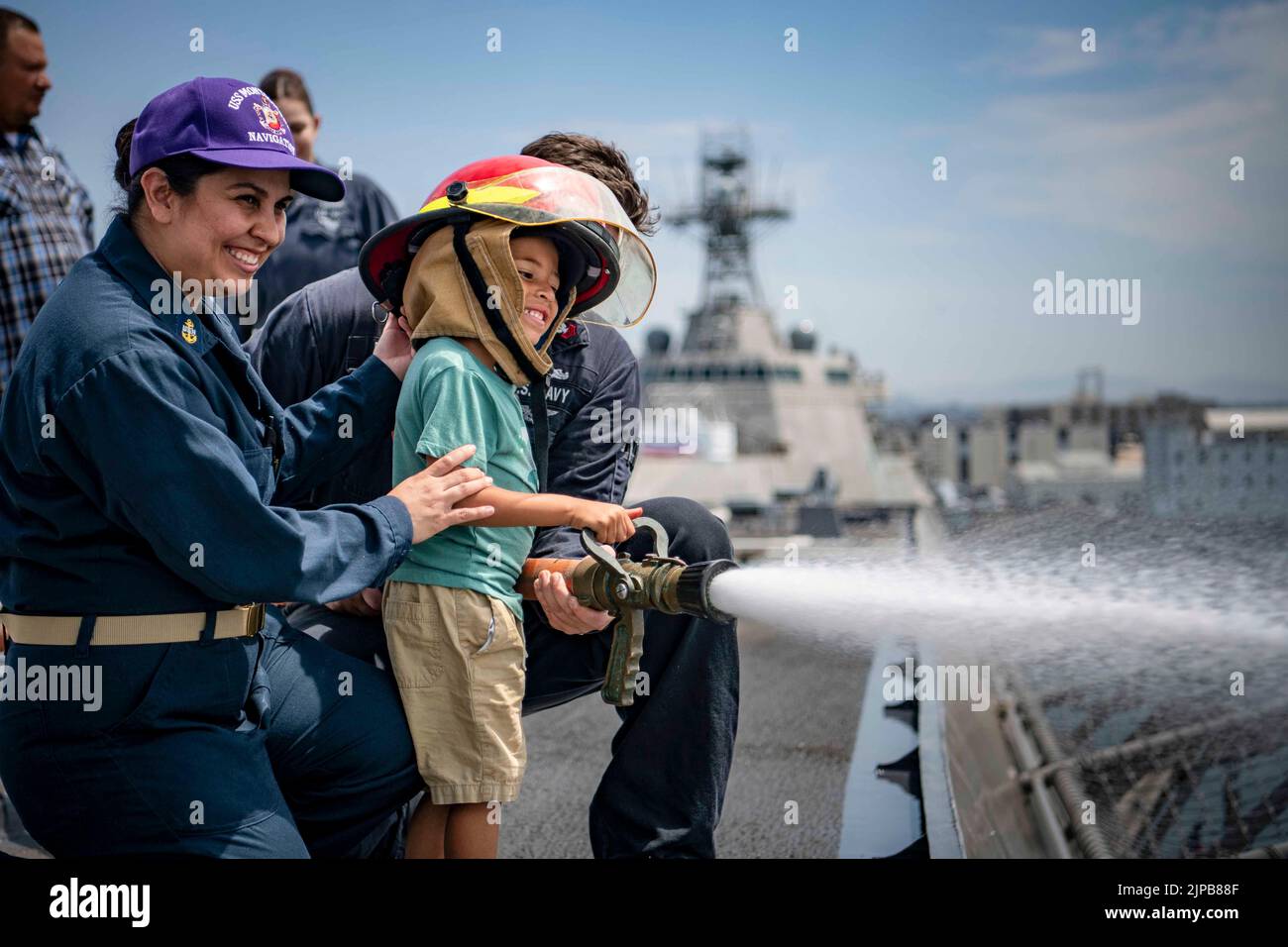 San Diego, California, USA. 4th Aug, 2022. Jayce Bridette, son of Chief Quartermaster Johanna Lopez, controls a fire hose on the flight deck of the Independence-variant littoral combat ship USS Montgomery (LCS 8) during a 'Friends and Family Day.' LCS are fast, agile, mission-focused platforms designed to operate in near-shore environments, winning against 21st-century coastal threats. LCS support forward presence, maritime security, sea control, and deterrence missions around the globe. Credit: U.S. Navy/ZUMA Press Wire Service/ZUMAPRESS.com/Alamy Live News Stock Photo
