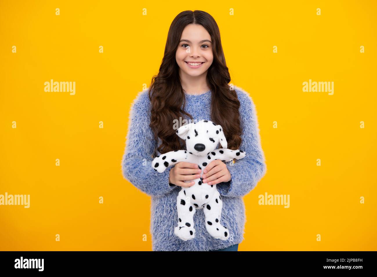 Teenager girl 12, 13, 14 year old hold soft toy for birthday on yellow background. Kid with her toys. Happy teenager, positive and smiling emotions of Stock Photo