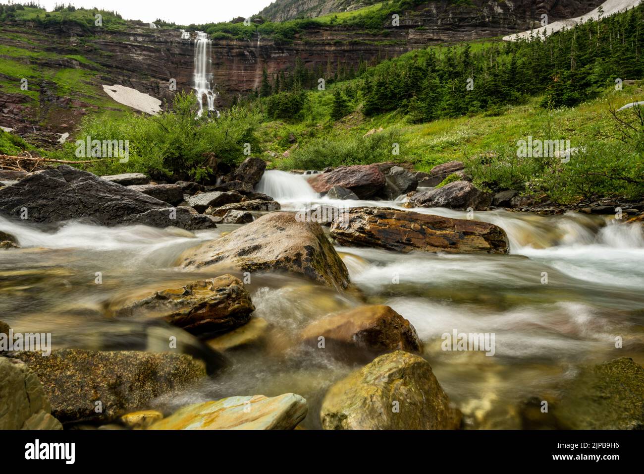 Low Angle of Cataract Creek With Morning Eagle Falls In The Distance in Glacier National Park Stock Photo