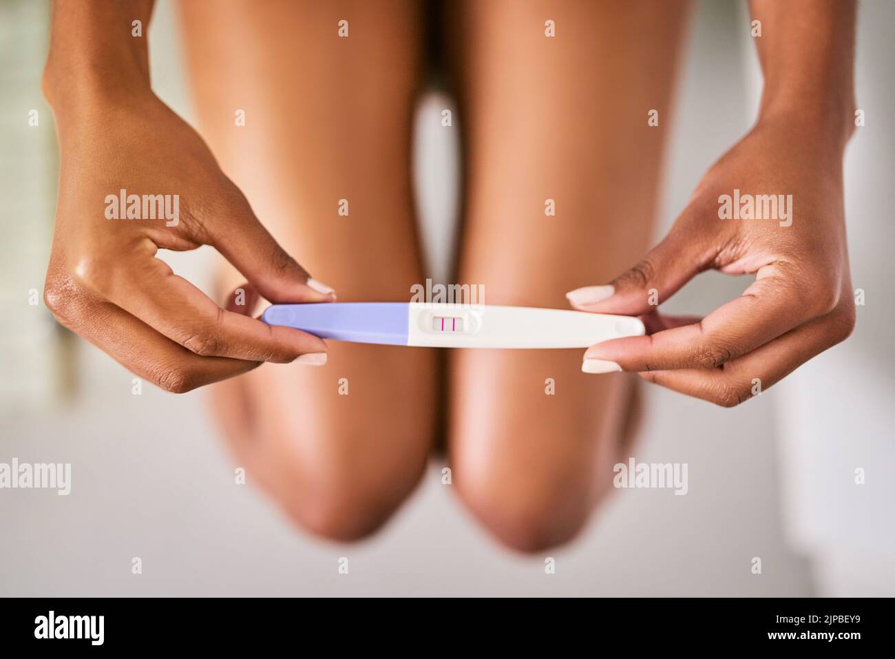 The start of a new chapter. a woman taking a pregnancy test while sitting on the toilet. Stock Photo