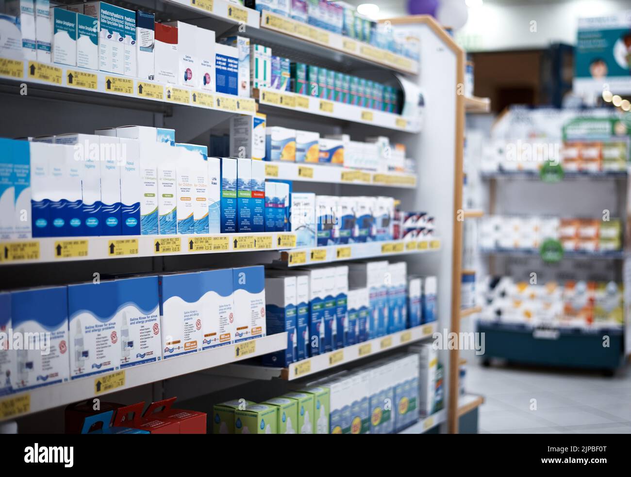 Every aisle is stocked with the health essentials you need. shelves stocked with various medicinal products in a pharmacy. Stock Photo