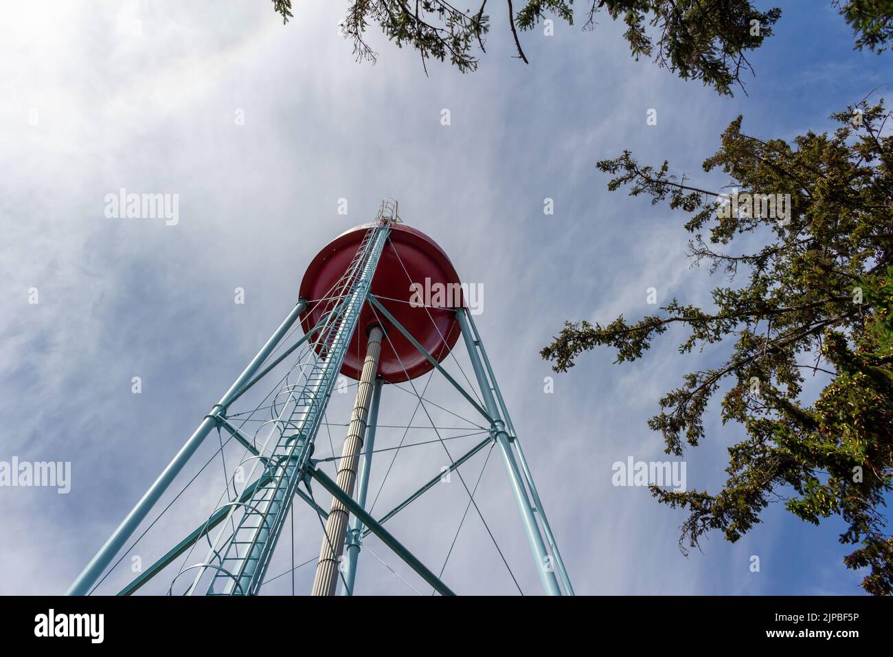 Upward view of a red and white round shaped water tower that resembles