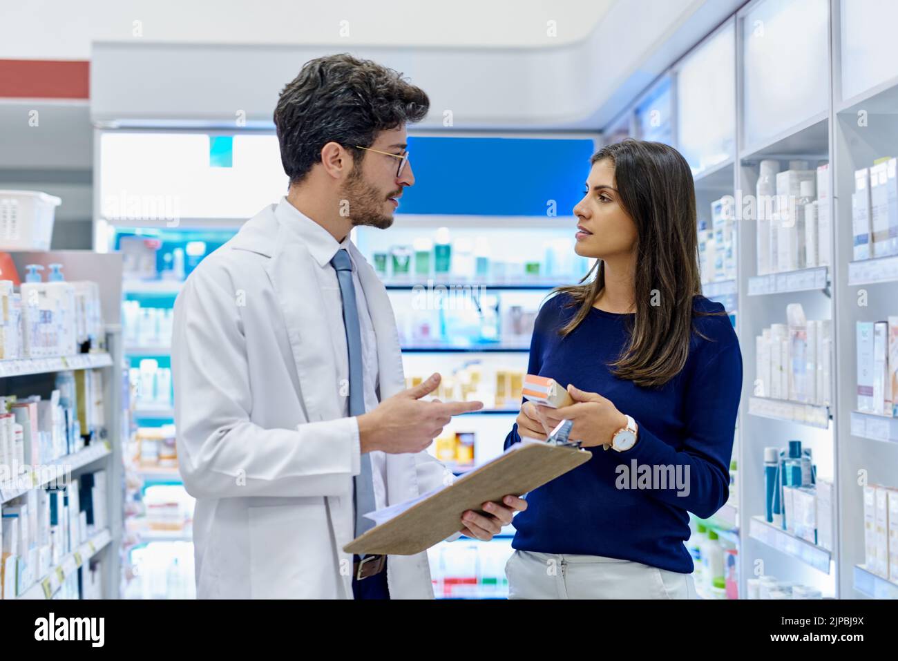 I recommend you take this daily to clear your symptoms. a pharmacist assisting a customer in a pharmacy. Stock Photo