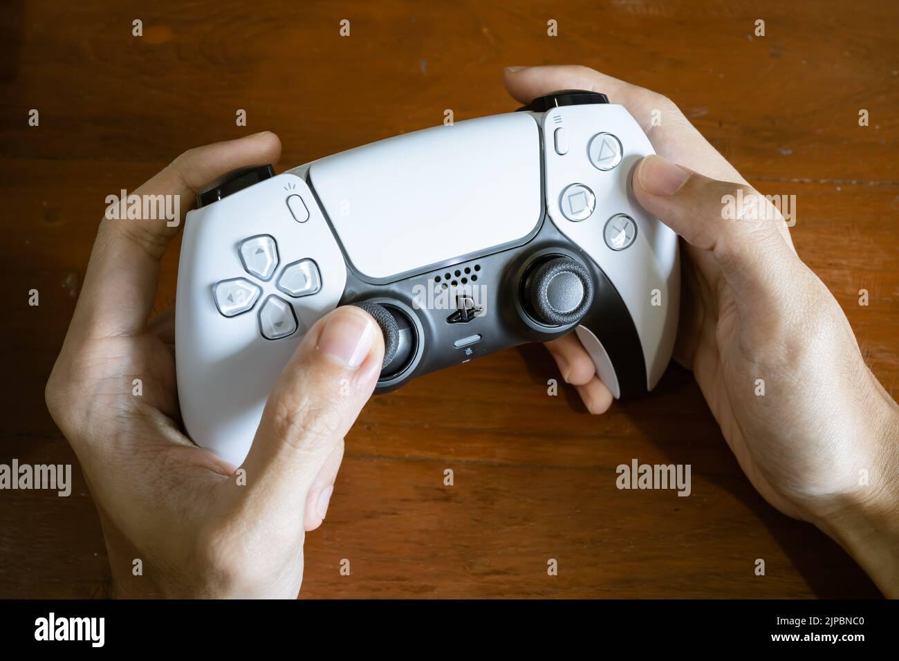 Bangkok, Thailand - July 28, 2022: Gamer playing PlayStation 5 game console with DualSense controller. Stock Photo