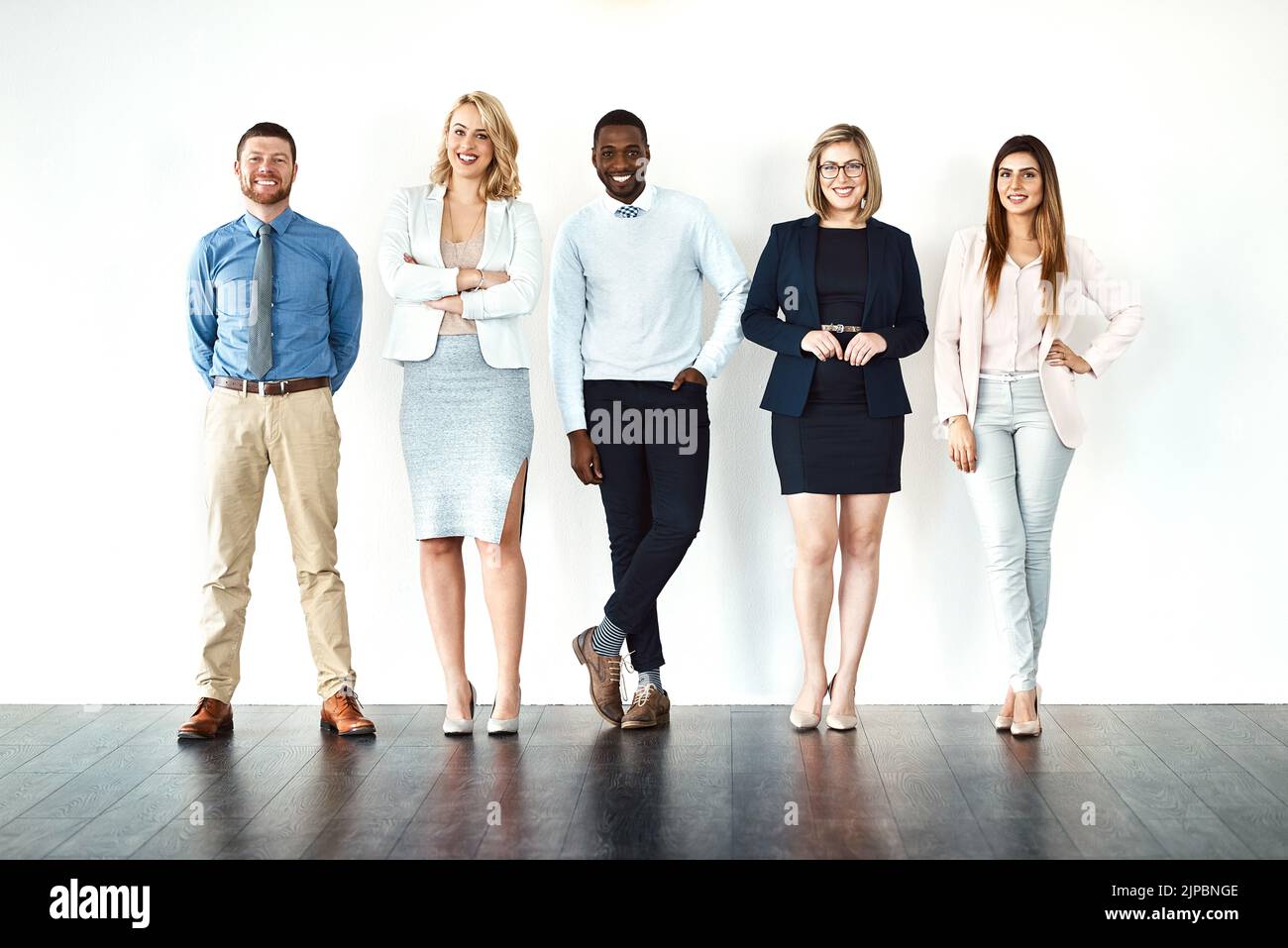 We call the shots. Portrait of a group of confident work colleagues standing with their arms folded against a white background. Stock Photo