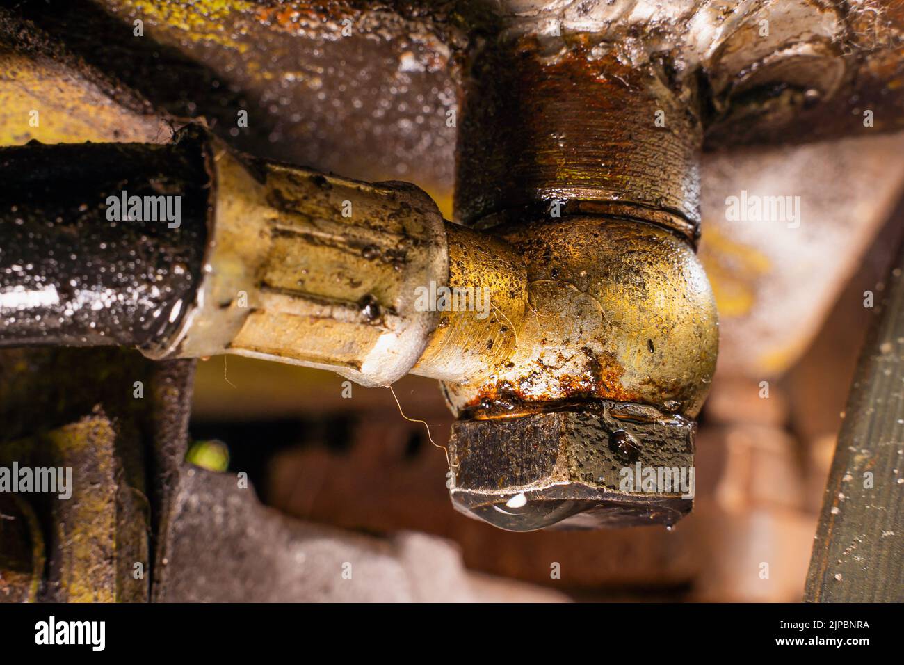 Fuel line angle connector with leaking fuel drop. Fuel leak near the