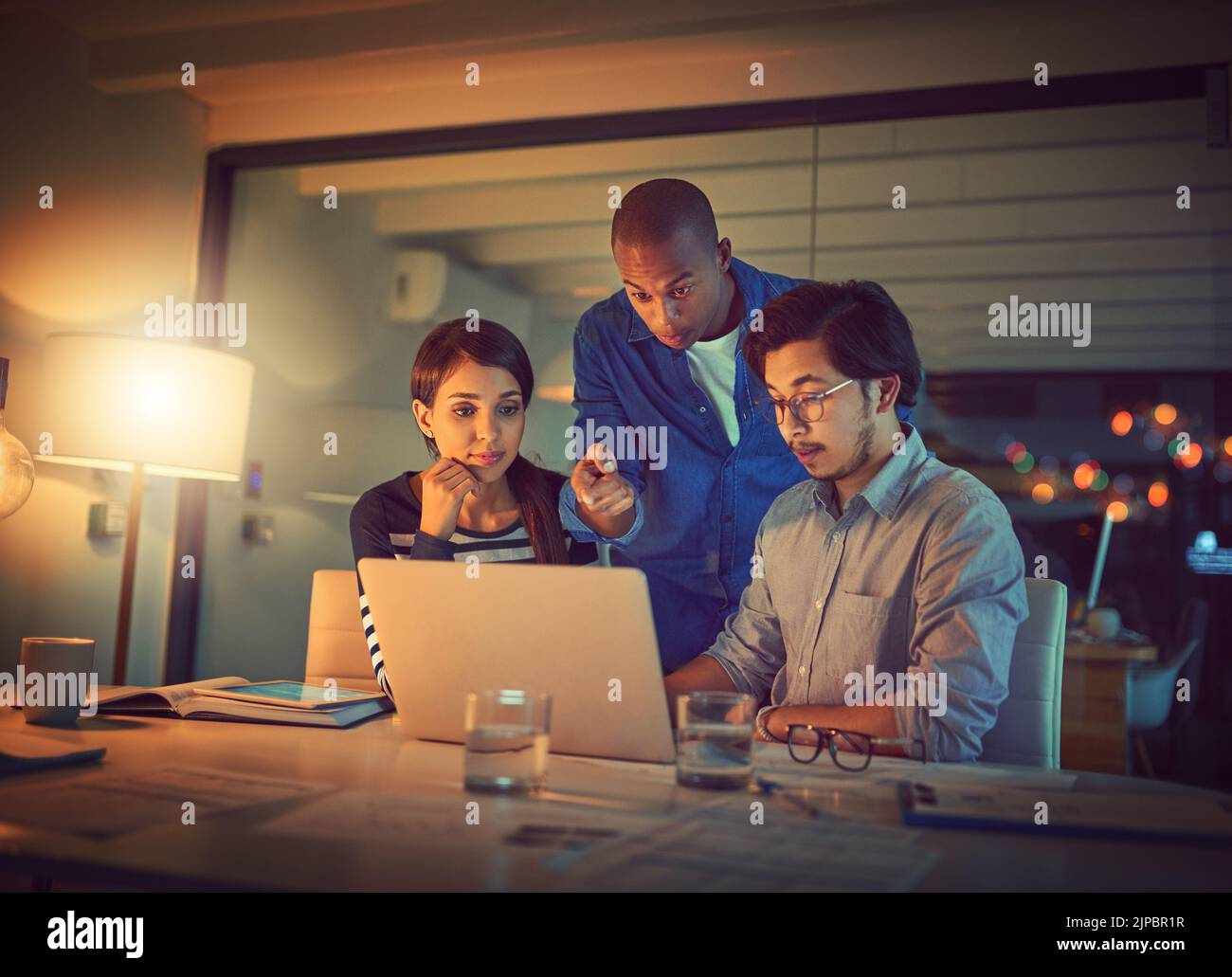 We need to fix that. a group of designers working late in an office. Stock Photo
